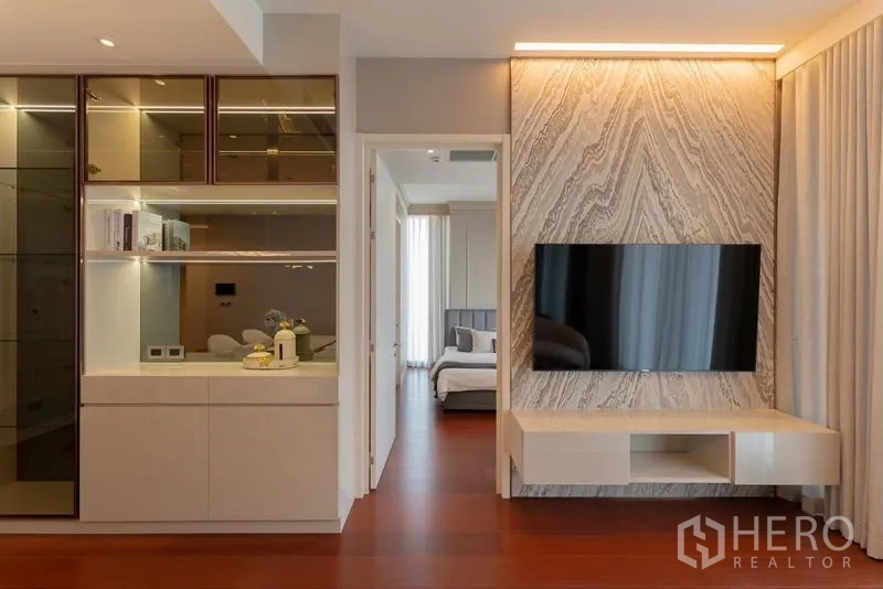 公寓 出租在Watthana, Bangkok - 石纹电视背景墙，旁边走廊通向卧室。