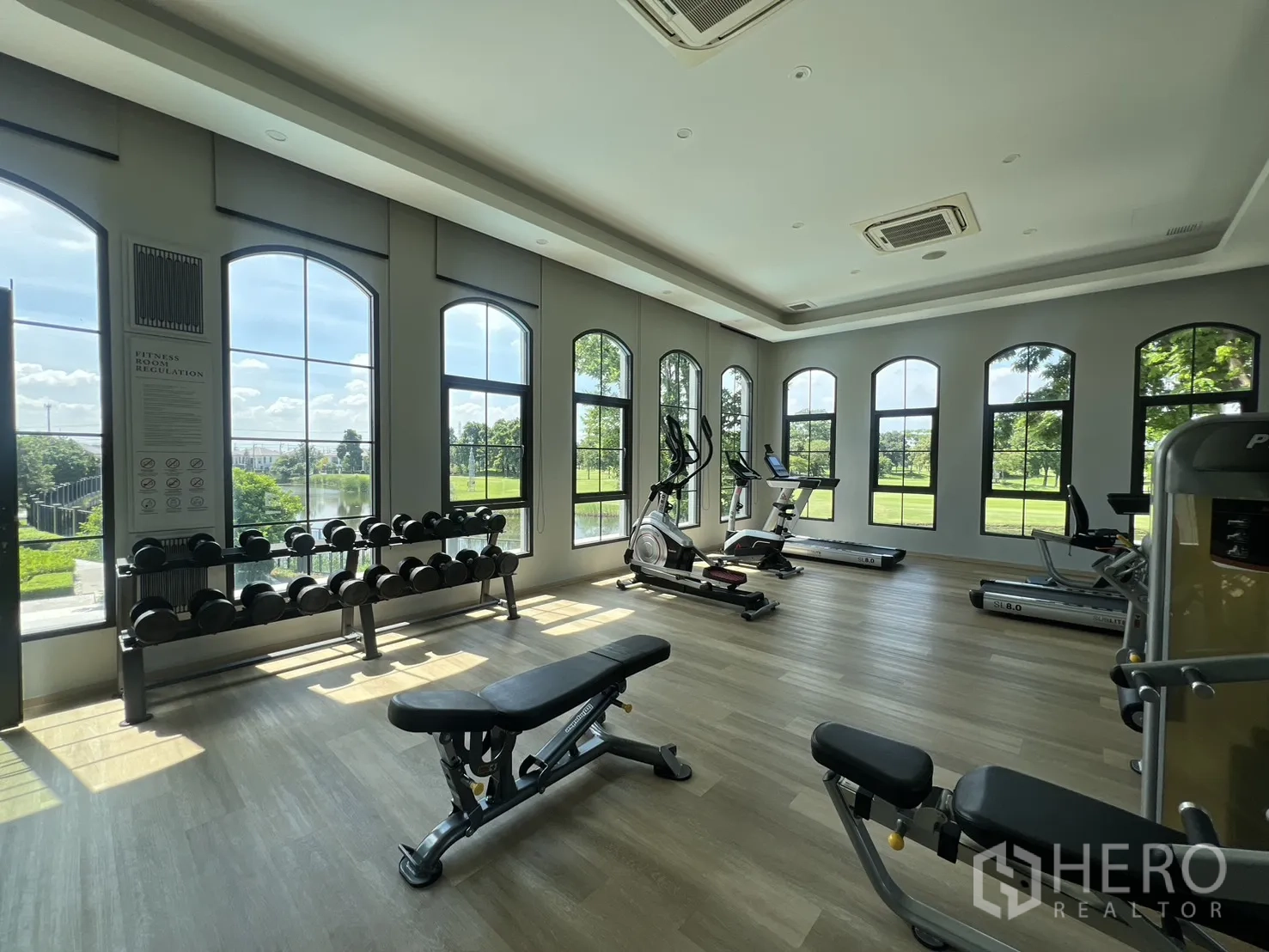 Detached House for rent or sale in Mueang Pathum Thani, Pathum Thani - Clubhouse co-working lounge with blue walls, island table and arched windows.