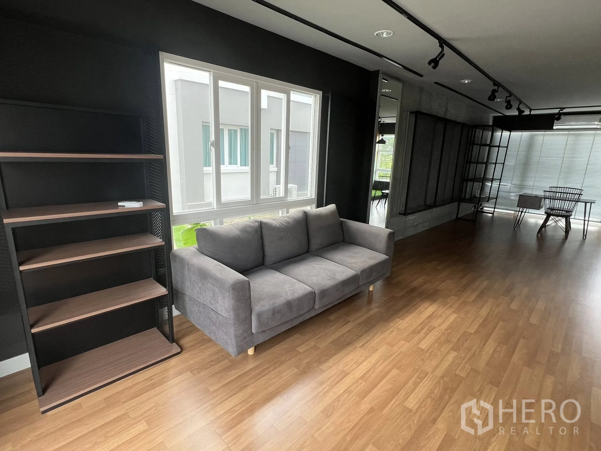 Detached House for rent or sale in Don Mueang, Bangkok - Cozy sofa corner beside bright window and freestanding shelves.
