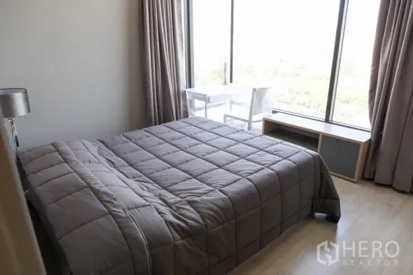 公寓 出租在Watthana, Bangkok - 卧室设大窗与双人床，浅色木地板