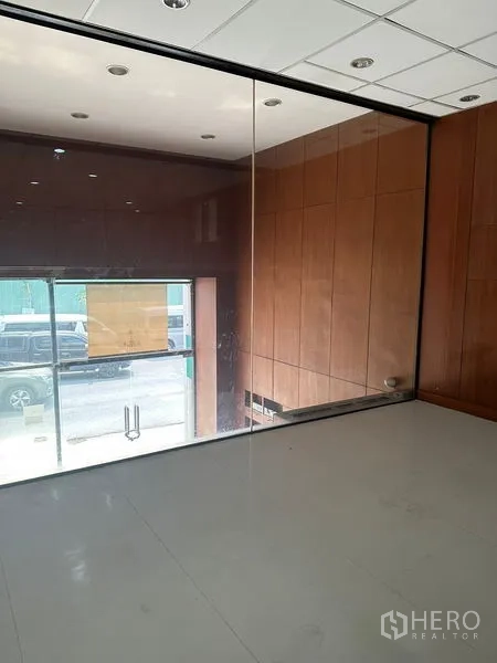 办公空间 出租在Pathum Wan, Bangkok - 玻璃墙会议室或独立办公室，俯瞰入口，木质墙面温暖质感。