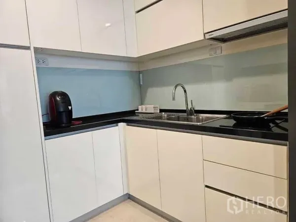 คอนโด ให้เช่าหรือขายในKhlong Toei, Bangkok - ครัวรูปตัวแอลสไตล์โมเดิร์น ตู้หน้ามัน เคาน์เตอร์สีดำ ผนังกระจก พร้อมอ่างล้างจานและเตาไฟฟ้า