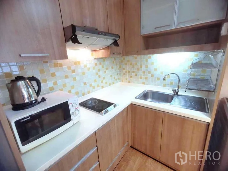 คอนโด ให้เช่าในWatthana, Bangkok - ครัวรูปตัวแอล กระเบื้องโมเสก เตา เครื่องดูดควัน ไมโครเวฟ ซิงก์ และตู้เก็บของ