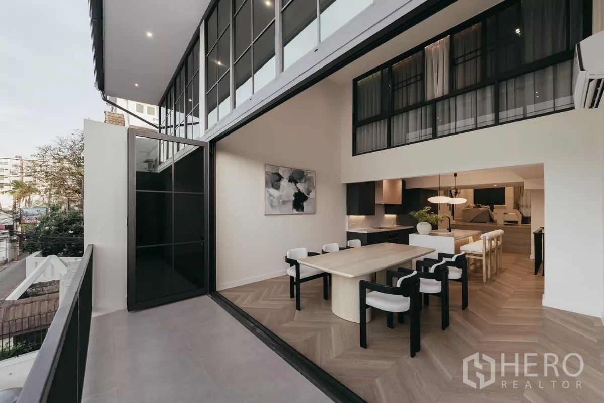 联排别墅 出租在Watthana, Bangkok - 餐厅与阳台相连，双层挑高落地窗，室内外通透。