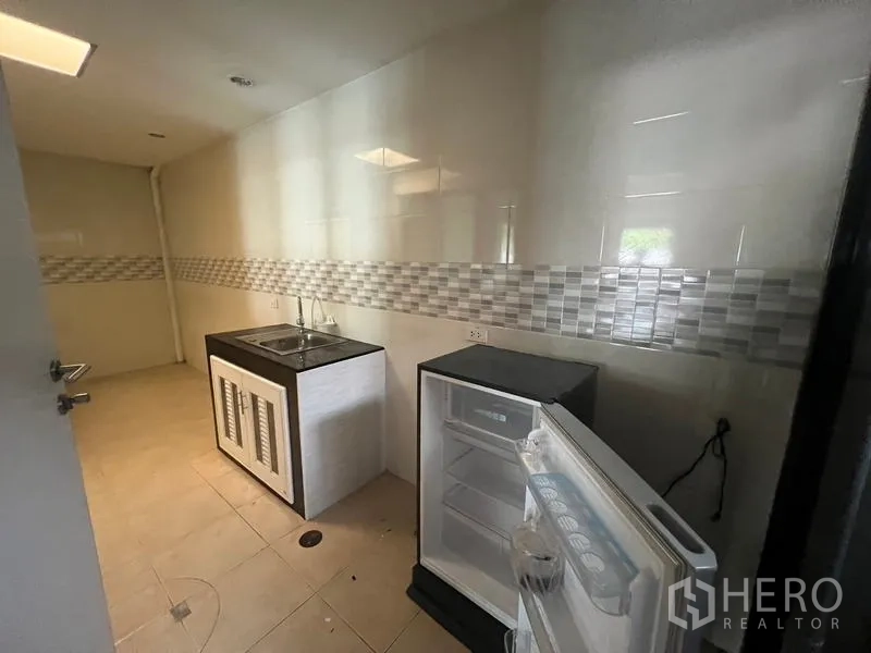 ทาวน์เฮาส์ ให้เช่าหรือขายในKhlong Toei, Bangkok - แพนทรีรองพร้อมอ่างล้างจานและตู้เย็นขนาดเล็ก ผนังกระเบื้อง