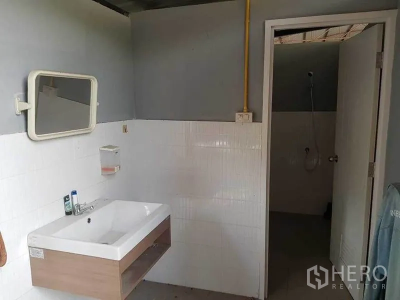 Warehouse for rent in Sai Noi, Nonthaburi - Restroom area with sink, mirror and a separate shower room.