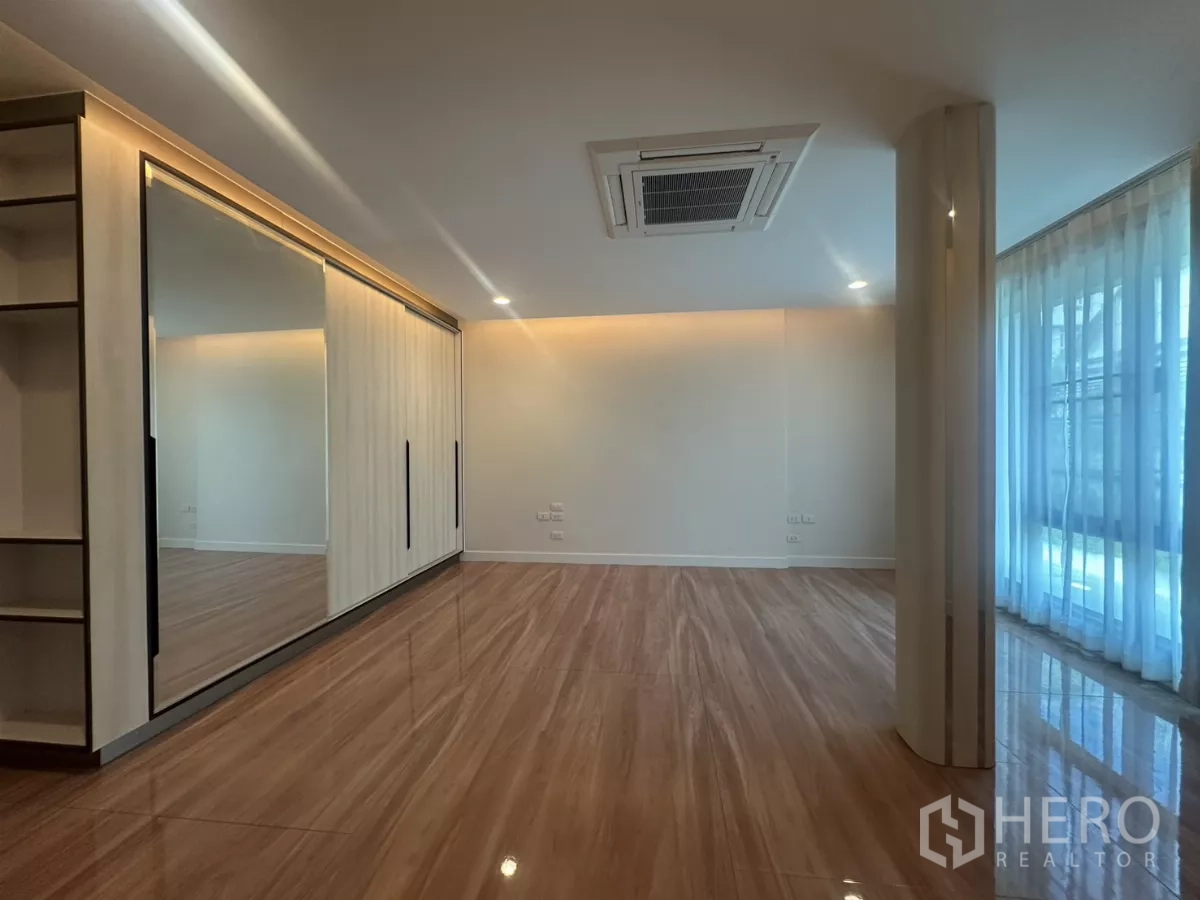 Townhouse for rent in Watthana, Bangkok - Master bedroom with mirrored wall wardrobe and ceiling cassette air-conditioner.