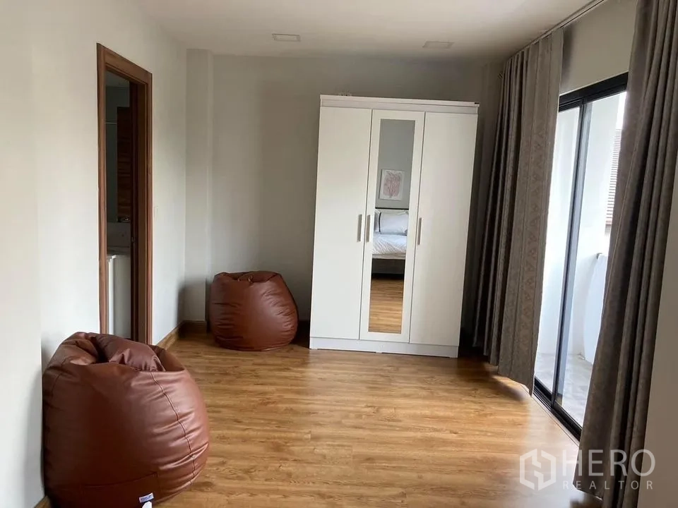 บ้าน ให้เช่าในKhlong Toei, Bangkok - ห้องอเนกประสงค์ ตู้เสื้อผ้าสีขาว บีนแบ็ก และทางออกสู่ระเบียง