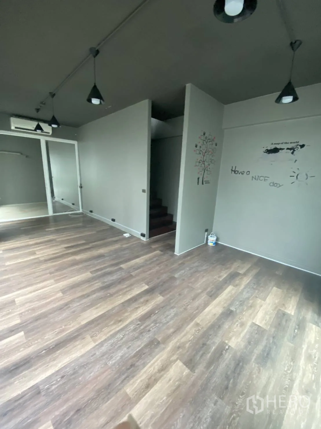 零售空间 出租在Huai Khwang, Bangkok - 室内配吊灯、灰色墙面、木地板及楼梯的零售空间。