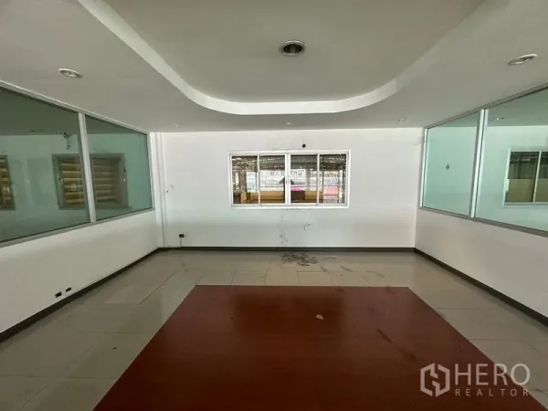 Showroom for rent or sale in Lam Luk Ka, Pathum Thani - Empty office room with tiled floor and internal windows.