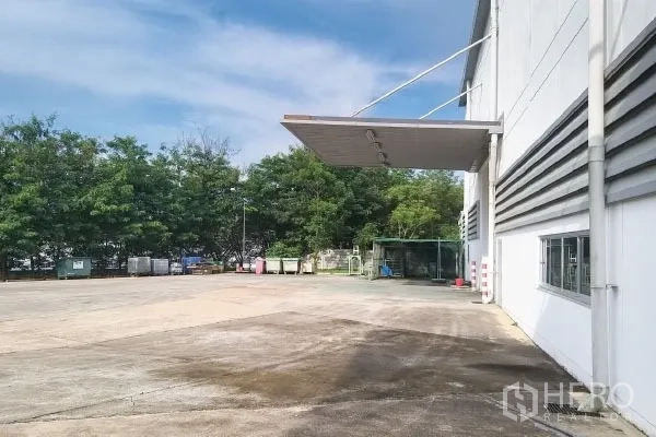 工厂 出售在Rayong - 工厂侧面宽阔混凝土场地，带雨棚并邻近绿化带。