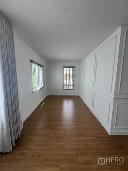 Detached House for rent or sale in Bang Bo, Samut Prakan - Sunlit multipurpose room with two windows, curtains, and wood floors.