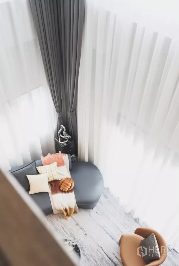 Detached House for rent in Bang Phli, Samut Prakan - Top-down view of lounge with curved sofa, armchair and black marble table.