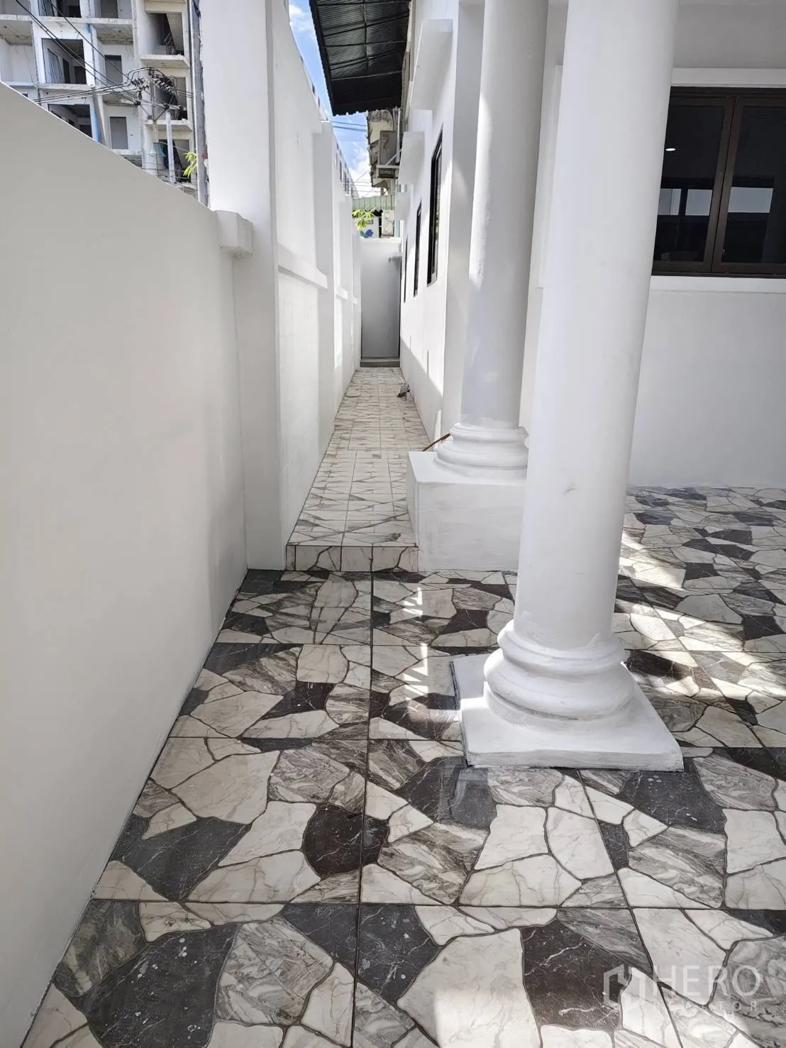 ทาวน์เฮาส์ ขายในPhra Khanong, Bangkok - ทางเดินข้างบ้านพร้อมเสาและพื้นกระเบื้องลายหิน