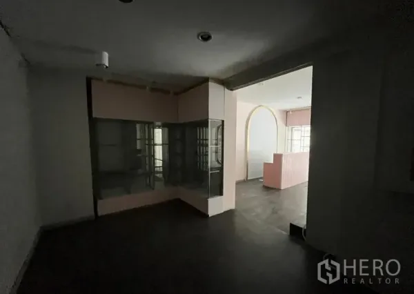 店屋 出租在Watthana, Bangkok - 后侧房间带玻璃展示柜，拱形开口通往前方店面。