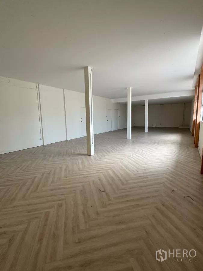 Shophouse for rent in Samphanthawong, Bangkok - Open-plan level with white columns and natural light from side windows.