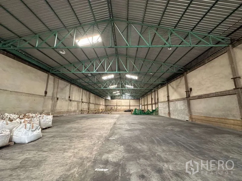 货栈 出租在Mueang Pathum Thani, Pathum Thani - 仓库内部通透，钢结构高屋架与采光天窗带来自然光。