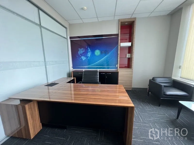 Office Space for rent in Huai Khwang, Bangkok - Executive office with a wood desk, lounge chair and a large window.