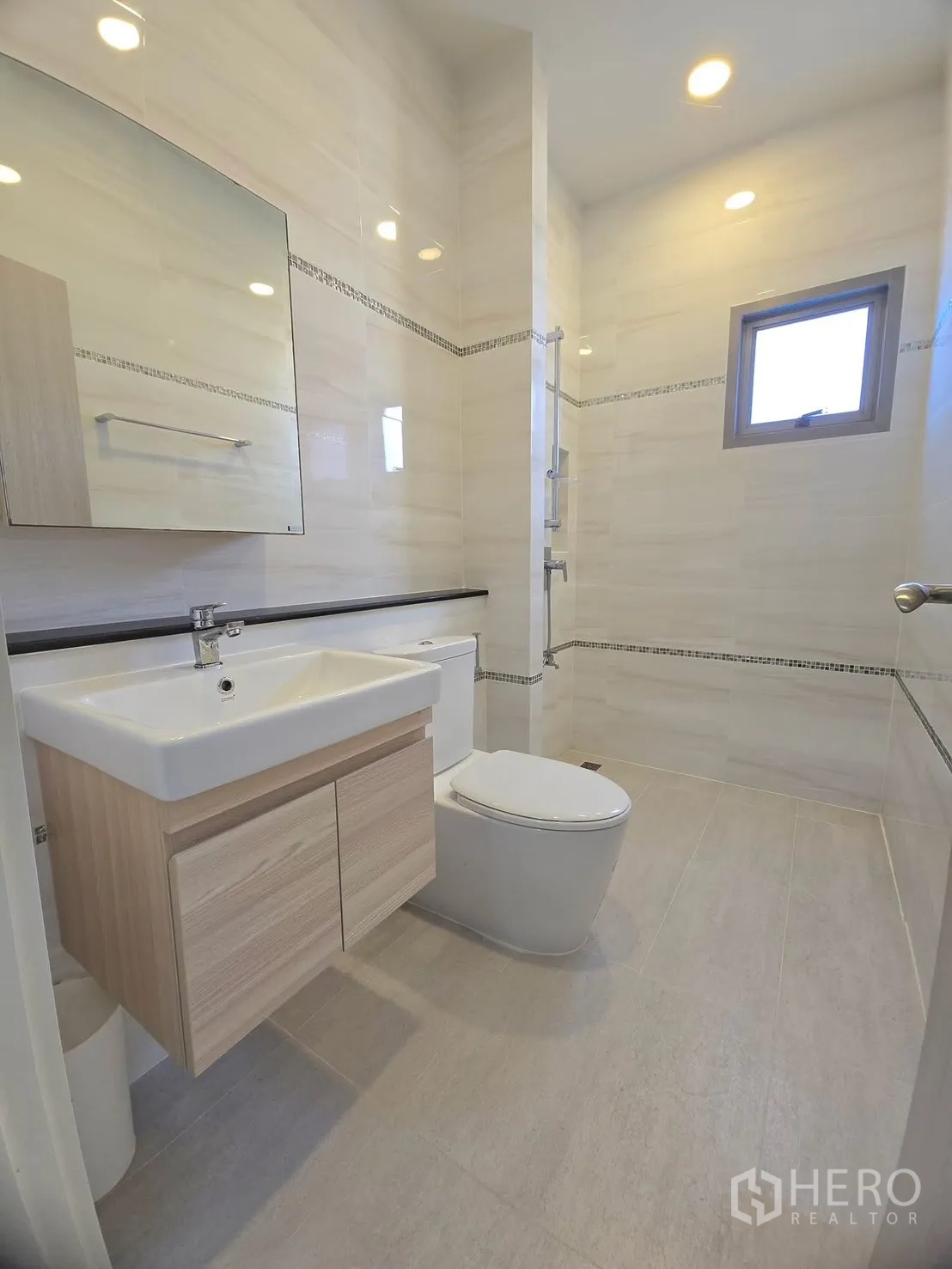 Detached House for rent in Lat Krabang, Bangkok - Bright bathroom with floating vanity, toilet and a small window.