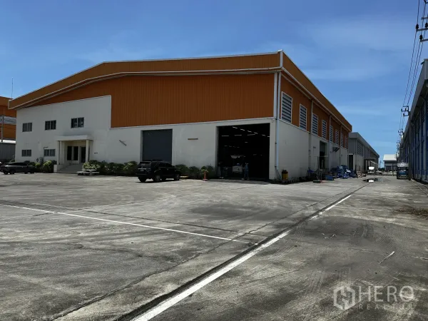 คลังสินค้า ให้เช่า - ภาพมุมเอียงแสดงประตูชัตเตอร์ของโกดังและพื้นที่เลี้ยวรถบรรทุกกว้าง