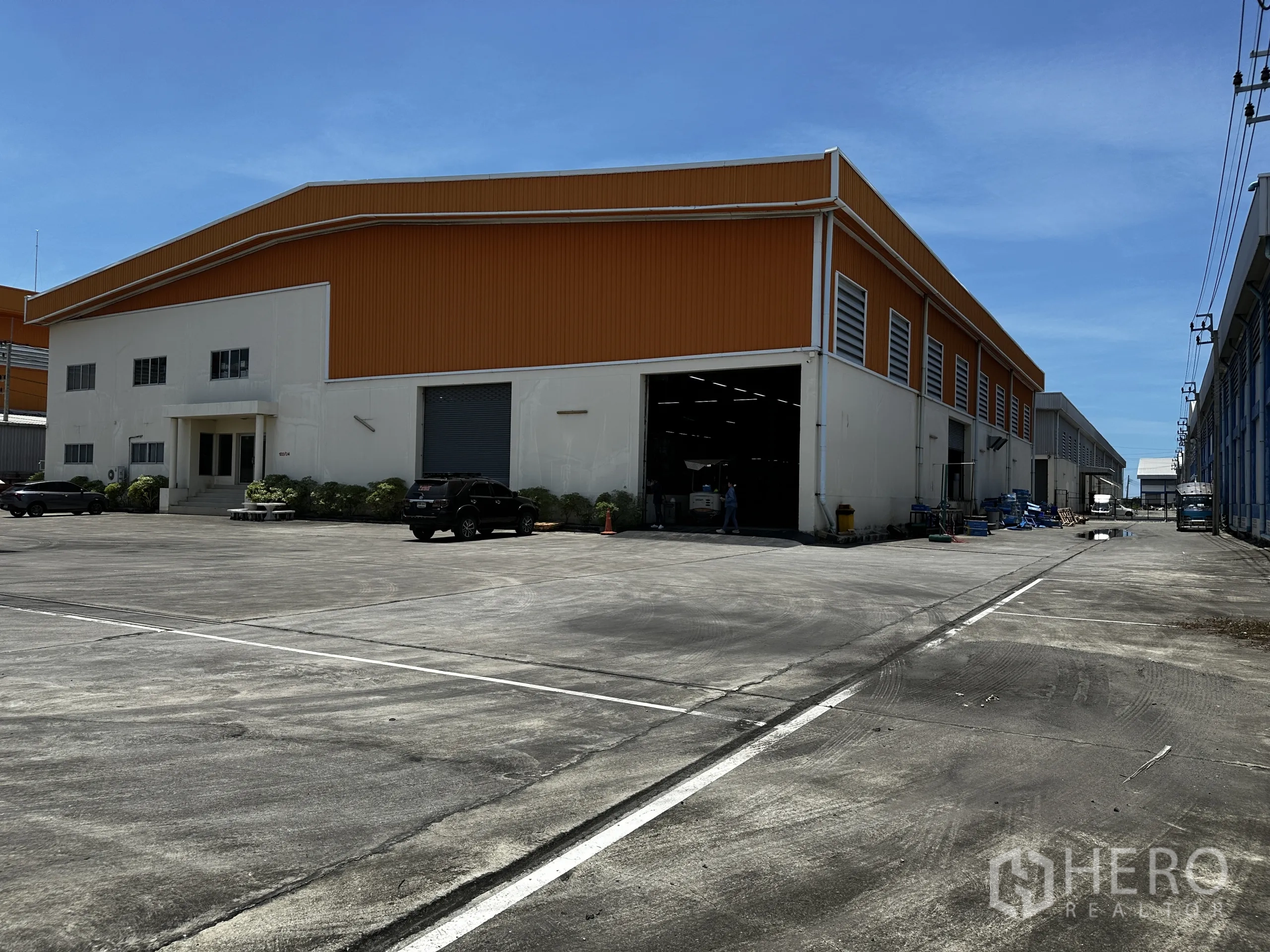 คลังสินค้า ให้เช่า - ภาพมุมเอียงแสดงประตูชัตเตอร์ของโกดังและพื้นที่เลี้ยวรถบรรทุกกว้าง