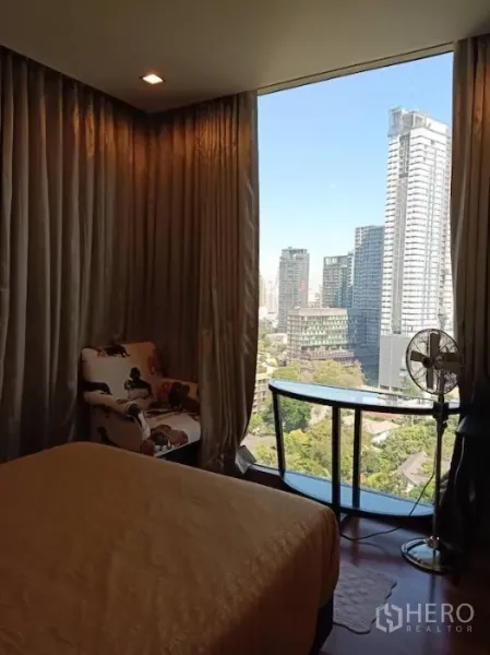 คอนโด ให้เช่าในKhlong Toei, Bangkok - ห้องนอนสว่างไสว มองเห็นวิวเมืองผ่านกระจกบานใหญ่ มีโต๊ะทำงานและชั้นกระจกโค้ง