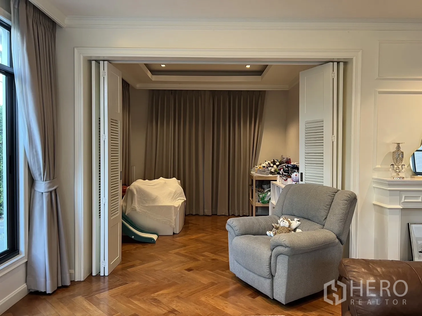 Detached House for rent in Suan Luang, Bangkok - Close view of the multipurpose room with folding doors and armchair.