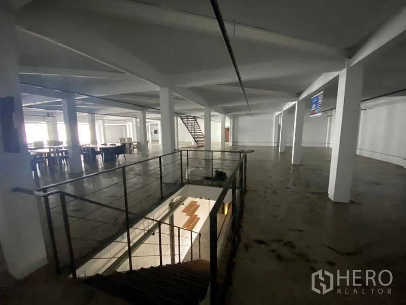 零售空间 出租在Bang Na, Bangkok - 宽阔开放楼层，白色立柱与中央楼梯开口。