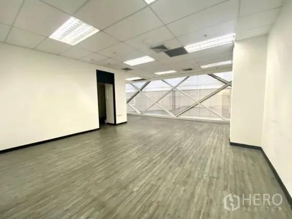 สำนักงาน ให้เช่าในKhlong Toei, Bangkok - สำนักงานแปลนโล่ง พื้นไวนิลลายไม้ ผนังสีขาว เพดานทีบาร์ และหน้าต่างบานใหญ่ค้ำโครงเหล็ก