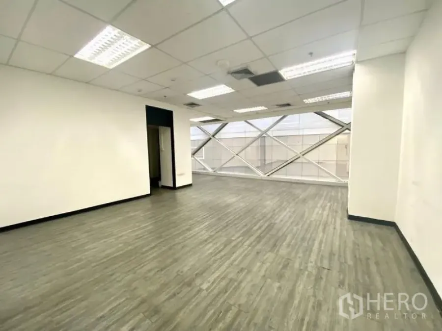 สำนักงาน ให้เช่าในKhlong Toei, Bangkok - สำนักงานแปลนโล่ง พื้นไวนิลลายไม้ ผนังสีขาว เพดานทีบาร์ และหน้าต่างบานใหญ่ค้ำโครงเหล็ก