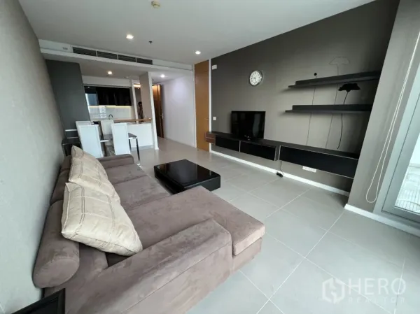 คอนโด ให้เช่าหรือขายในKhlong San, Bangkok - มุมนั่งเล่นสไตล์ร่วมสมัย ผนังชั้นลอย ทีวี และบาร์ครัวข้างโซฟาโทนอบอุ่น