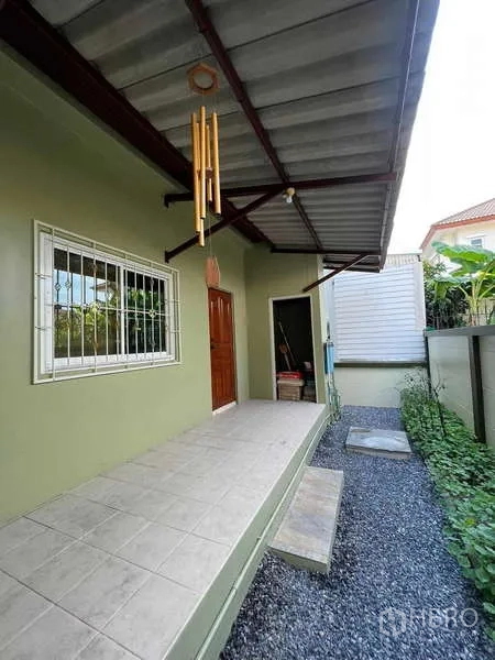 สำนักงานที่บ้าน ให้เช่าหรือขายในMin Buri, Bangkok - ทางเดินข้างบ้านมีหลังคา เหล็กดัดหน้าต่าง และสวนโรยกรวด