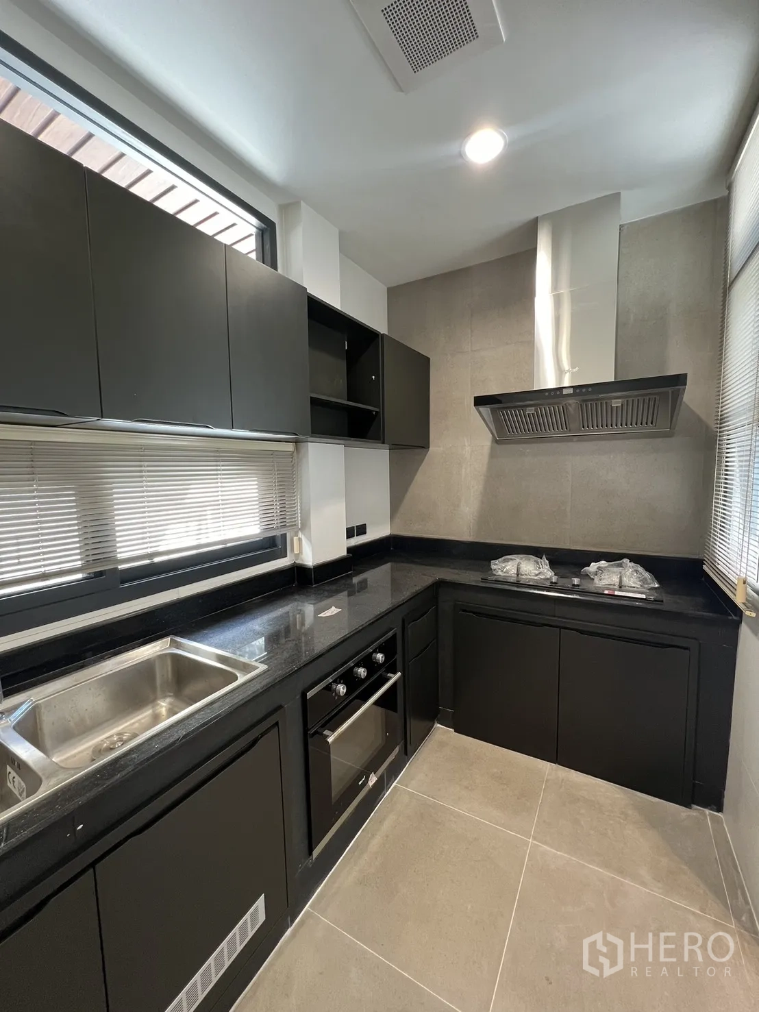 บ้าน ให้เช่าในSaphan Sung, Bangkok - ครัวยุคใหม่ตู้สีดำ เคาน์เตอร์หิน เตาอบและฮู้ดดูดควันรูปตัวยู