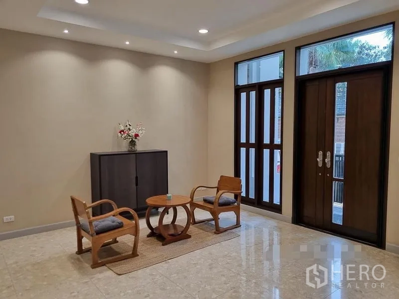 Detached House for rent in Bang Khae, Bangkok - Entry foyer with double doors, tall windows, polished floors and a small seating set.