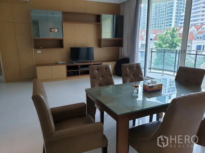 Condominium for rent in Watthana, Bangkok - Bright dining and living area with glass table, wall unit, balcony and city view in an Asok area condo, Watthana, Bangkok.