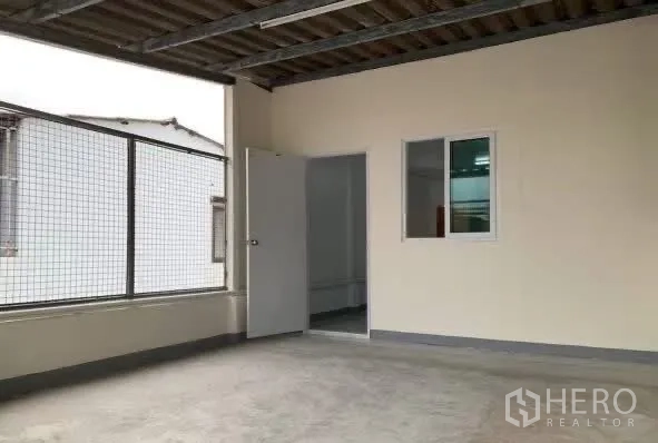 Home Office for rent in Sathon, Bangkok - Covered rooftop terrace with mesh fencing and a doorway to a room.