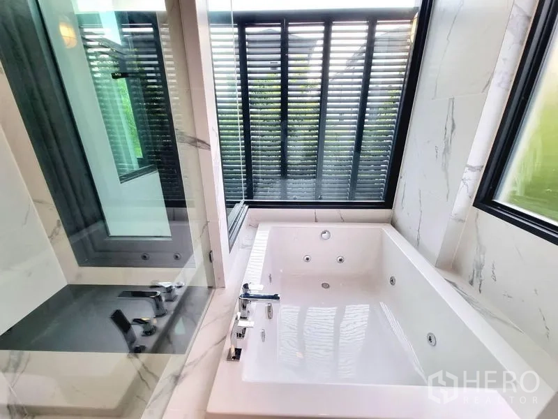 独立式住宅 出租 - 大理石浴室内的按摩浴缸，临近带百叶的窗户。