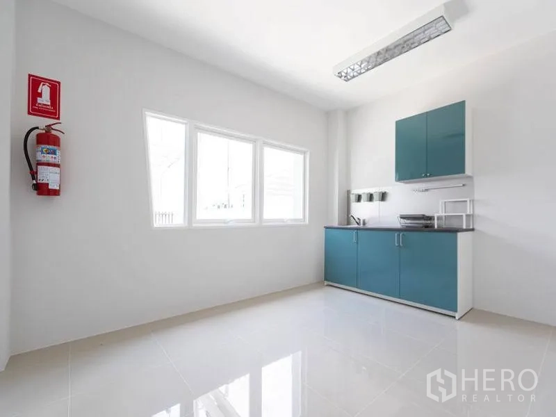 工厂 出租在Bang Bo, Samut Prakan - 茶水间配青绿色橱柜与水槽，带窗户及墙式灭火器