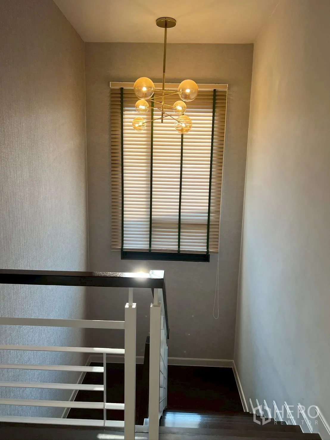 独栋房屋 for rent in Bang Kapi, Bangkok - 楼梯间，球形枝形吊灯与高窗百叶。