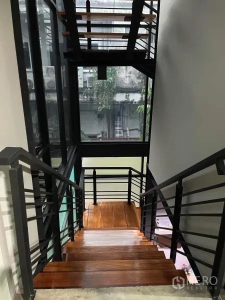 办公空间 出租在Khlong Toei, Bangkok - 室内楼梯，黑色金属框架与实木台阶，配大面积采光窗。