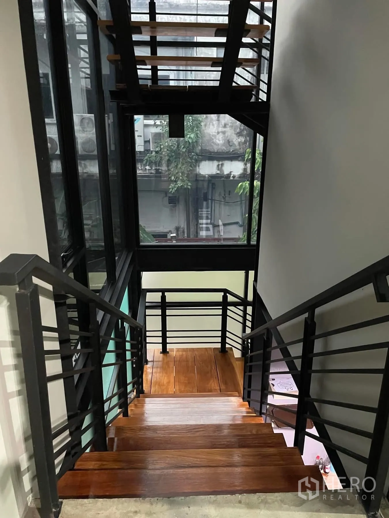 办公空间 出租在Khlong Toei, Bangkok - 室内楼梯，黑色金属框架与实木台阶，配大面积采光窗。