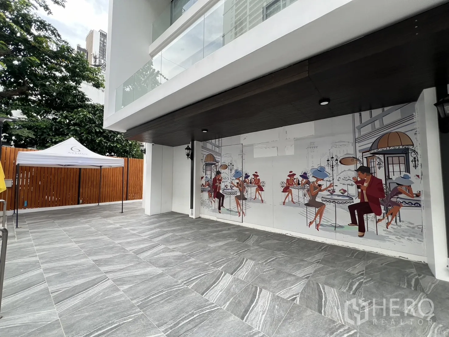 พื้นที่ขายปลีก ให้เช่า - ลานหน้าร้านกว้างหน้ากำแพงภาพวาด รายล้อมด้วยต้นไม้จัดสวน