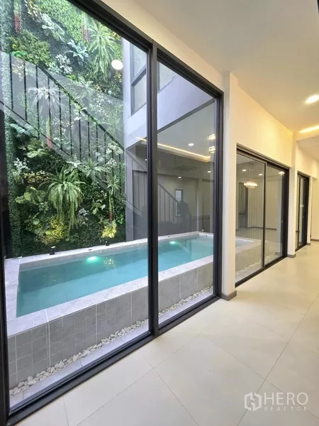 บ้าน ขายในKhlong Toei, Bangkok - มุมโถงทางเดิน มองผ่านกระจกเต็มบานไปยังสระและสวนแนวตั้ง