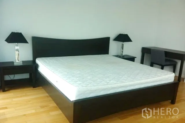 คอนโด ขายในKhlong Toei, Bangkok - ห้องนอนหลัก เตียงคิงไซส์ โต๊ะข้างพร้อมโคมไฟ และโต๊ะทำงาน พื้นไม้