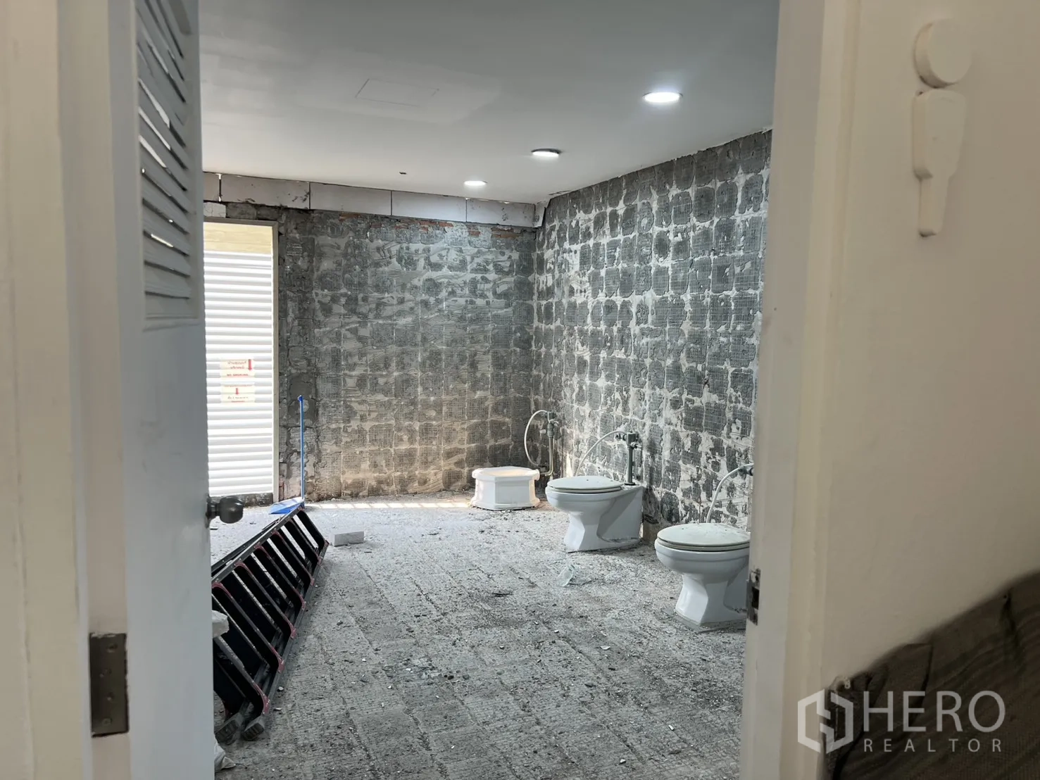 办公空间 出租在Watthana, Bangkok - 从门口看到未完工的洗手间，多个坐便器与粗糙墙面。