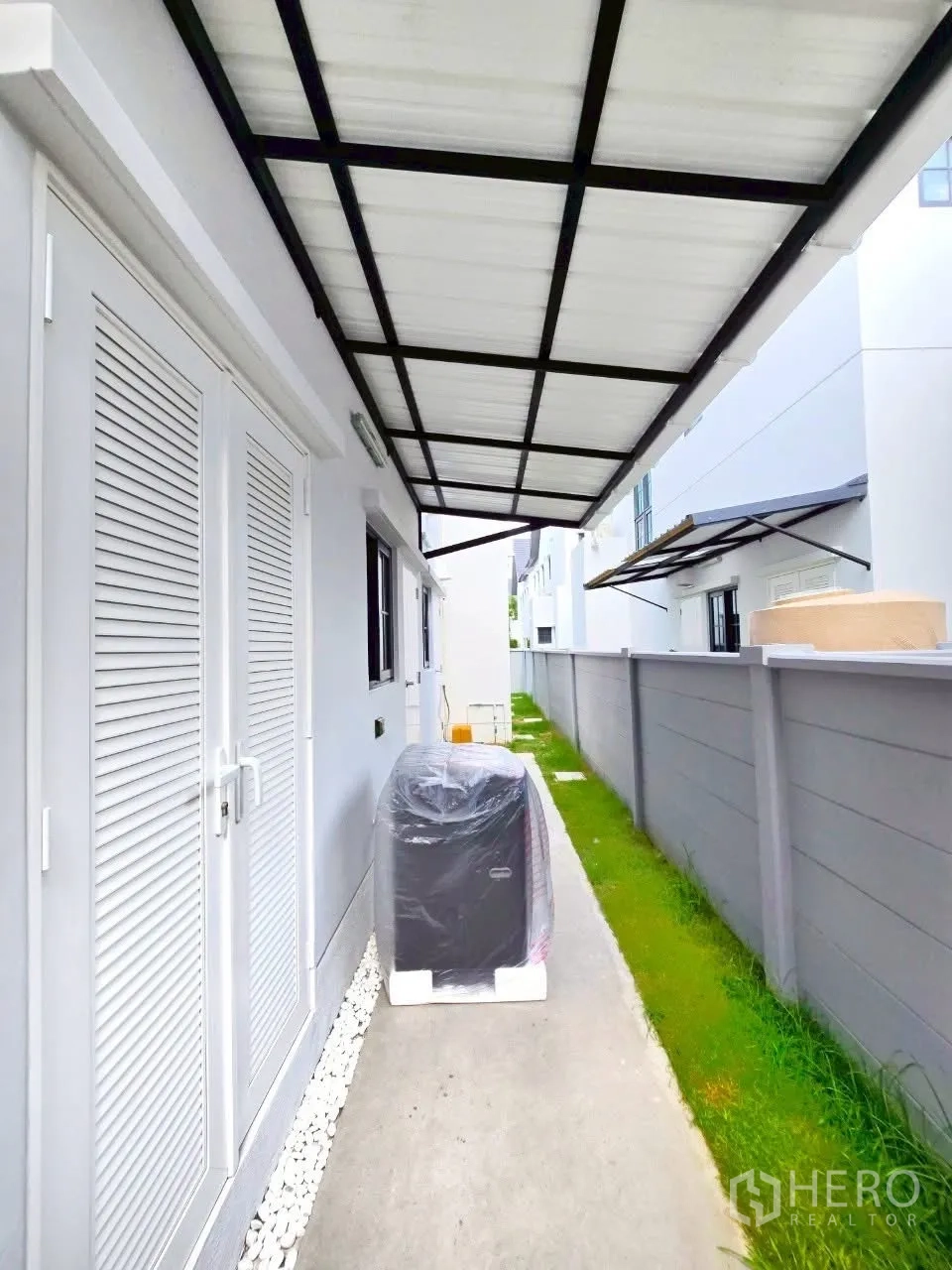 独栋房屋 for rent in Bang Phli, Samut Prakan - 带顶侧廊与草坪的通道，旁有围墙