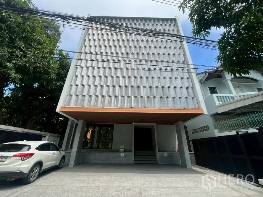 带办公室的家 出租或出售在Phra Khanong, Bangkok - 现代3.5层家庭办公楼外立面，带大门车道与停车位