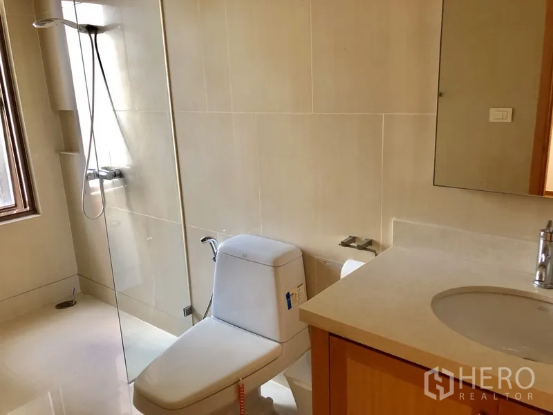 คอนโด ให้เช่าในKhlong Toei, Bangkok - ห้องน้ำสมัยใหม่พร้อมฉากกั้นอาบน้ำกระจก โถสุขภัณฑ์ และเคาน์เตอร์อ่างล้างหน้าโทนหินอ่อน