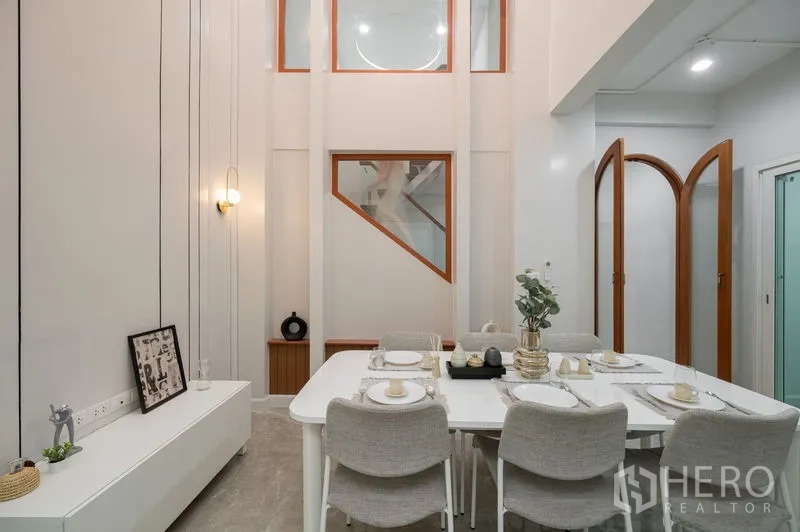 Townhouse for sale in Din Daeng, Bangkok - Dining zone facing staircase and arched doors in renovated townhouse.