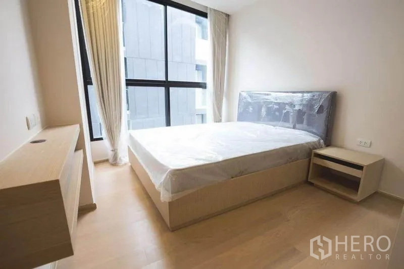 คอนโด ให้เช่าในWatthana, Bangkok - ห้องนอนใหญ่ หน้าต่างบานสูง เตียงคู่ และโต๊ะข้างเตียง